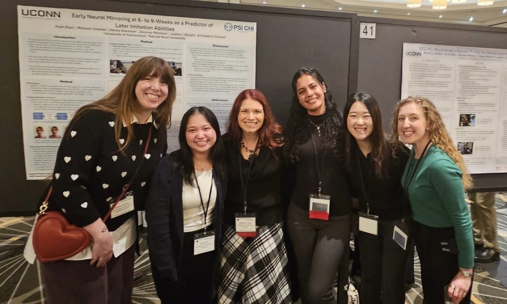 Dr. Cuevas and 5 CAP Lab members in front of conference posters